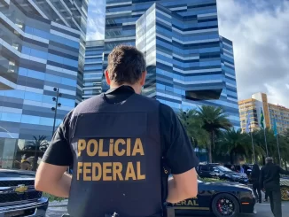 Agente da Polícia Federal durante operação contra o PCC no setor de combustíveis em totalidade com edifícios e veículos na cidade.