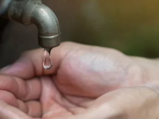 Pessoa colocando a mão sob água de torneira com o nível de captação do Cantareira em situação crítica após corte pela Sabesp.