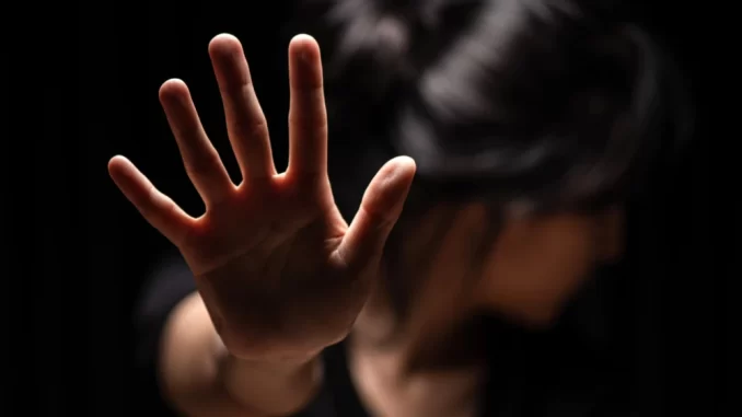 denuncias-de-estupro-caem-3-1-em-julho-no-estado-de-sp Mulher com expressão triste e mão estendida, simbolizando a denúncia de estupro, em destaque para a redução de 3,1% nas denúncias em julho no Estado de São Paulo.