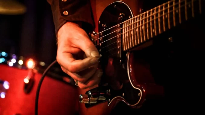 lei-federal-reconhece-guitarrada-como-bem-cultural-brasil Homem tocando guitarra elétrico, destacando a importância da música na cultura brasileira reconhecida pela lei federal como bem cultural do Brasil.