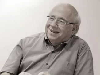 Foto de Luis Fernando Verissimo, renomado escritor e humorista brasileiro, sorrindo em entrevista ou evento, em homenagem a sua contribuição para a literatura e humor.