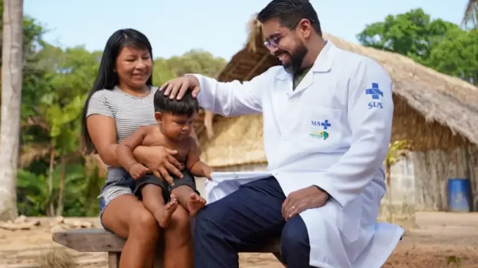 mais-medicos-1500-novos-profissionais-zona-rural Profissional de saúde do programa Mais Médicos interagindo com uma criança e uma mulher em zona rural brasileira, promovendo cuidado e atenção à saúde.