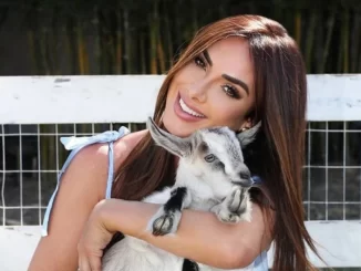 Nicole Bahls batiza cabritos com nomes de colegas do quadro Dança dos Famosos, mostrando alegria enquanto segura cabritinho em ambiente ao ar livre.