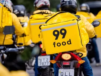 Repartição de entregadores do serviço de delivery da 99 Food, celebrando plano de investimento de R$ 2 bilhões até 2026 para expandir suas operações.