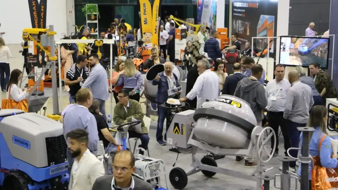 Participantes participando do Analoc Rental Show 2026 no Expo Center Norte em julho, apresentando equipamentos de construção e tecnologia avançada.