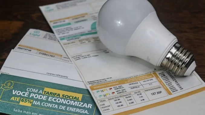 bandeira-vermelha-conta-de-luz-mais-cara-setembro Contas de luz com bandeira vermelha que mantém a tarifa mais cara em setembro, incluindo um boleto de energia e uma lâmpada, ilustrando o aumento na conta de luz.