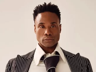Billy Porter abandona musical 'Cabaret' após diagnóstico grave de sepse, mostrando uma expressão séria e vestindo roupa social estilosa.