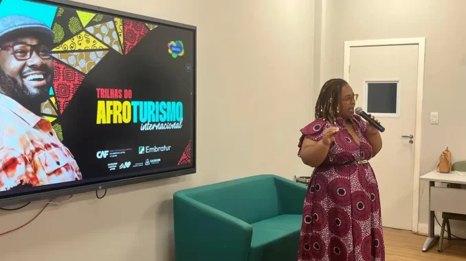 embratur-lanca-novo-guia-racial-impulsiona-afroturismo-brasil-jpg Lançamento do novo guia racial pelo Embratur para impulsionar o afroturismo no Brasil, apresentando uma líder falando em evento de divulgação.