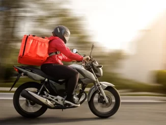 Entrega de delivery de aplicativo na rua, com recepção de autógrafos sendo aprovada com urgência na Câmara para obrigar vale-refeição a entregadores.