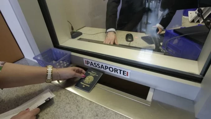 entrega-passaporte-para-visto-turismo-usa-jpg Pessoa entregando passaporte no balcão de atendimento para a renovação de visto de turismo para os Estados Unidos, com a mensagem 'Entrevista volta a ser obrigatória para visto de turismo aos EUA' em destaque.