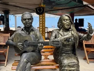 Estátua de Preta Gil ao lado de uma estátua de Gilberto Gil, representando ícones da música brasileira, instaladas juntas em um espaço ao ar livre.