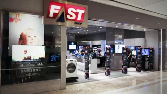 fastshop-pagara-100-milhoes-resultado-acordo-mpsp Imagem da loja FastShop dentro de shopping com destaque para o logo vermelho e branco da FastShop, e várias telas de TV e caixas de automação ao fundo.