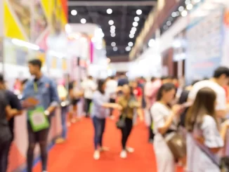 Imagem de uma feira ou exposição movimentada, com diversas pessoas interagindo e explorando diferentes stands em um ambiente vibrante e cheio de energia, destacando a importância do setor que movimenta bilhões e gera milhões de empregos no Brasil e no mundo.