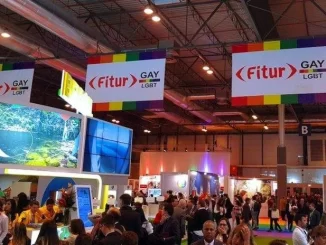 Ambiente vibrante na feira FITUR LGBT+ 2026, destacando a inclusão e inovação no turismo global com diversas pessoas explorando diferentes estandes e atrações.