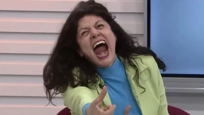 Gilda Nomacce surpreende telejornal ao gritar durante entrevista ao vivo, mostrando uma expressão de surpresa e intensidade.