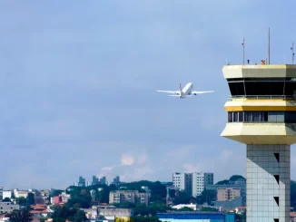 Controle de tráfego aéreo na Torre de controle de aeroporto com avião decolando ao fundo, ilustrando possível impacto na aviação devido à greve dos controladores da NAV Brasil.