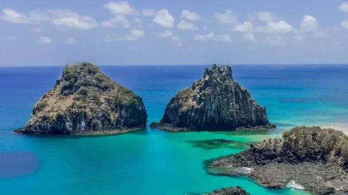 ilhas-oceanicas-brasileiras-especies-endemicas Paisagem de ilhas oceânicas brasileiras com mar azul claro, rochedos e vegetação, destacando espécies endêmicas em estudo.