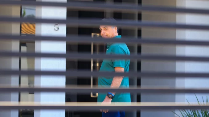 jair-bolsonaro-condenacao-stf-27-anos-por-golpe-de-estado Imagem de Jair Bolsonaro visto através de grades ou cortinas, enquanto aguarda julgamento, relacionado ao caso de condenação por crimes relacionados ao golpe de estado de acordo com decisão do STF.