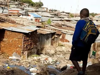 Jovem caminhando por uma área de moradias precárias em uma comunidade de baixa renda, simbolizando esperança de mudanças sociais e melhorias econômicas.