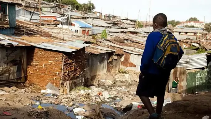 mais-de-65-milhoes-de-familias-saem-da-pobreza-em-2-anos Jovem caminhando por uma área de moradias precárias em uma comunidade de baixa renda, simbolizando esperança de mudanças sociais e melhorias econômicas.
