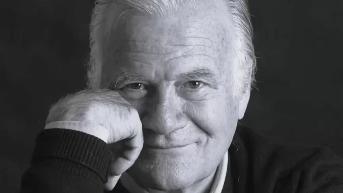 mino-carta-morto-aos-91-criador-da-veja-carta-capital Imagem de Mino Carta, criador da Veja e Carta Capital, sorrindo para a câmera em retrato preto e branco, aos 91 anos, memória de um jornalista influente.