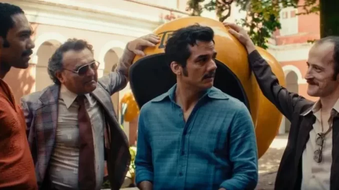 o-agente-secreto-filme-brasil-oscar-2026-jpg Cena do filme 'O Agente Secreto', selecionado para representar o Brasil no Oscar 2026, mostrando atores em uma reunião com cenário de cidade ao fundo.