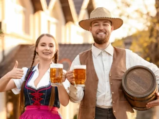 Participantes na Primeira Oktoberfest de Gramado, comemorando com chope e vestindo trajes típicos alemães, projetando público superior a 100 mil visitantes.