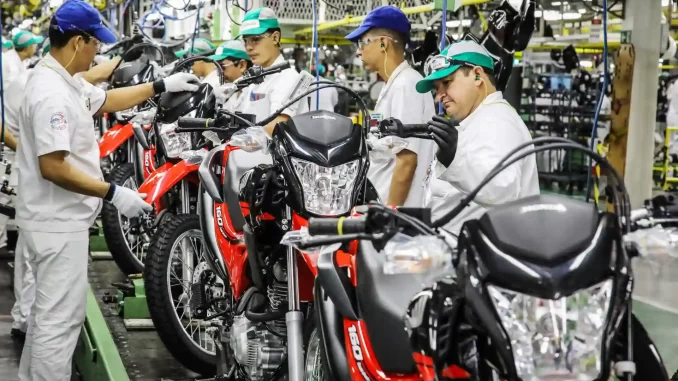 producao-de-motos-atinge-melhor-desempenho-de-agosto Fábrica de motocicletas atingindo melhor desempenho de produção em agosto com equipes de trabalhadores monitorando a linha de montagem de motos.