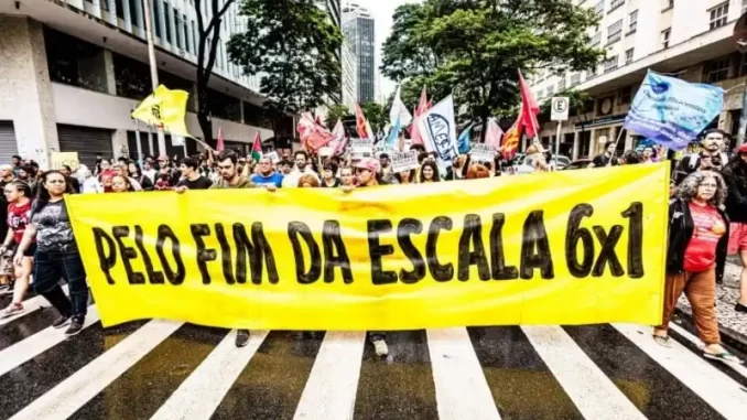 protesto-pelo-fim-da-escalada-6x1-e-pressao-popular (1) Manifestantes participam de protesto nas ruas do centro da cidade, segurando faixas que pedem o fim da escalada 6x1 e pressão popular por mudanças.