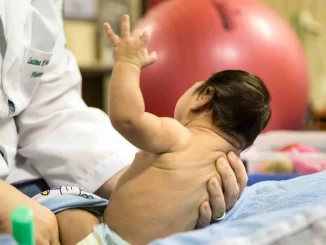 Recém-nascido em atendimento médico, simbolizando vítimas da Zika, relacionado à portaria fixa pensão vitalícia e indenização para afetados.