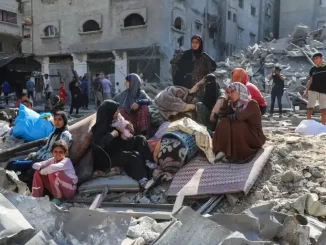 Imagem de civis de Gaza entre destroços de edifícios destruídos, após ataque, destacando a crise humanitária e o relatório da ONU sobre o genocídio israelense.