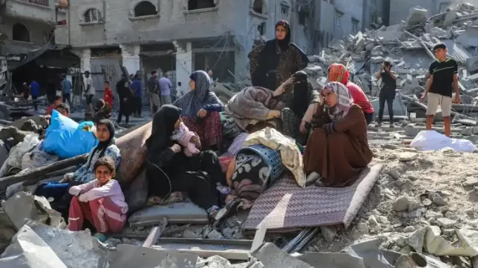 relatorio-comissao-onu-genocidio-israelense-gaza Imagem de civis de Gaza entre destroços de edifícios destruídos, após ataque, destacando a crise humanitária e o relatório da ONU sobre o genocídio israelense.