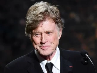 Imagem de Robert Redford, lenda de Hollywood e voz do cinema independente, em uma cerimônia, refletindo uma expressão serena e digna.
