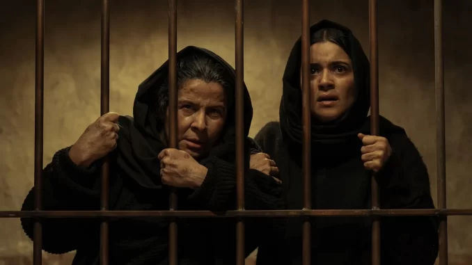 serie-as-mortas-ep-final-destino-arcangela-serafina Cena do episódio final da série 'As Mortas', mostrando Arcángela e Serafina atrás das grades, com expressões de preocupação e medo.