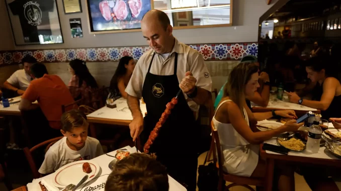 setor-servicos-avanca-03-em-julho-ate-recorde-jpg Profissional atendendo clientes em restaurante movimentado reflete crescimento do setor de serviços, que avança 0,3% em julho e atinge recorde.