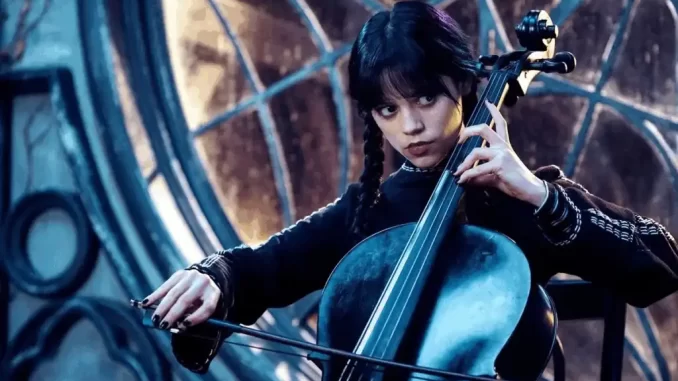 wandinha-segunda-temporada-trilha-sonora-classicos-ineditas-jpg Cena da segunda temporada de Wandinha, com personagem tocando violino em cenário futurista e misterioso, representando a trilha sonora marcada por clássicos e inéditas.