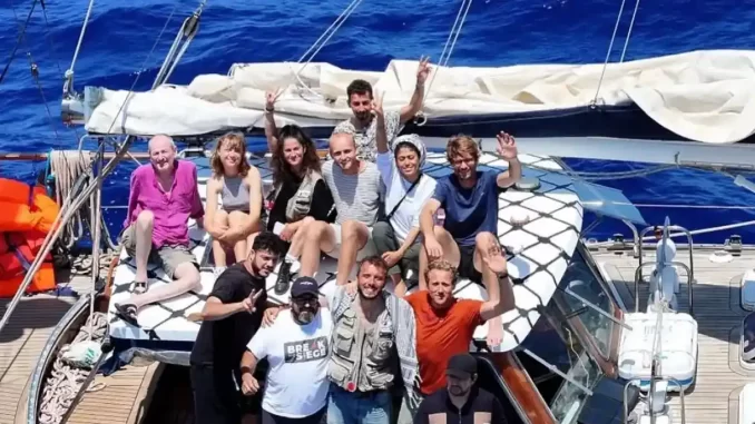 brasileiros-capturados-israel-flotilha-gaza Dez brasileiros sendo capturados pela Israel em uma flotilha rumo a Gaza, imagem mostra uma equipe de pessoas em um veleiro, celebrando. Contexto: Israel captura dez brasileiros em flotilha humanitária rumo a Gaza.