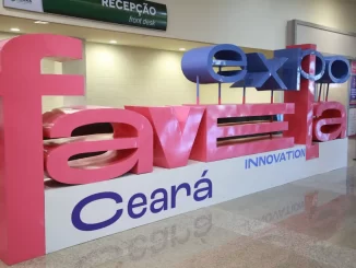 Imagem da sinalização do Expo Favela Ceará 2025 no aeroporto, destacando a oportunidade de participar como expositor gratuito, com foco em inovação e desenvolvimento da favela.