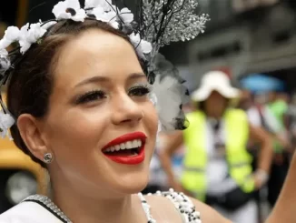Leandra Leal em comemoração de Carnaval, falando sobre chances no Oscar 2025, com sorriso encantador e roupas tradicionais, em ambiente festivo.