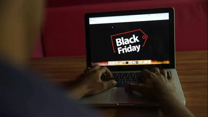 Pessoa acessando a pesquisa do Procon-SP sobre hábitos de compra na Black Friday em um laptop com a tela exibindo o logo de Black Friday.