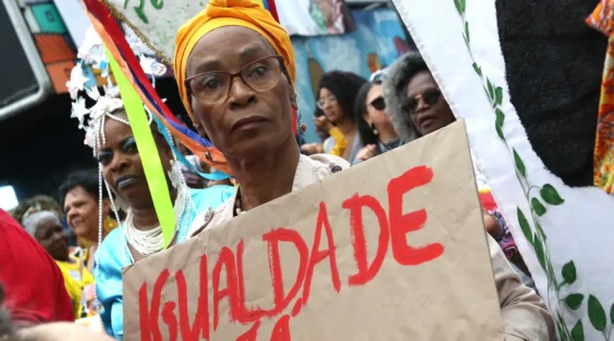 protesto-direitos-iguais-raciais-mulher Mulher em protesto segurando cartaz com a palavra 'Igualdade' em uma manifestação pelo dia da consciência negra, destacando a baixa presença de órgãos de igualdade racial nos municípios brasileiros, conforme o IBGE.