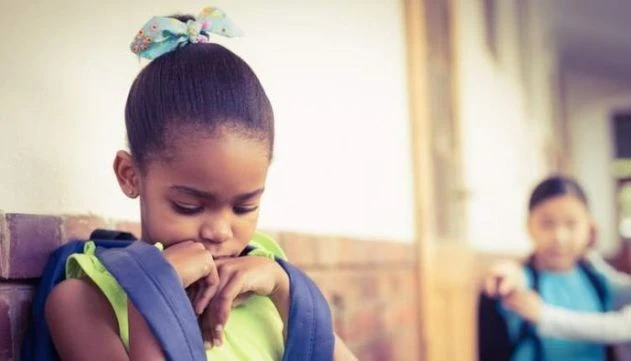 racismo-atinge-uma-em-cada-seis-criancas-pequenas Pesquisa revela que o racismo afeta uma em cada seis crianças pequenas, demonstrando o impacto social do preconceito desde a infância, como ilustrado por menina com mochila na escola.