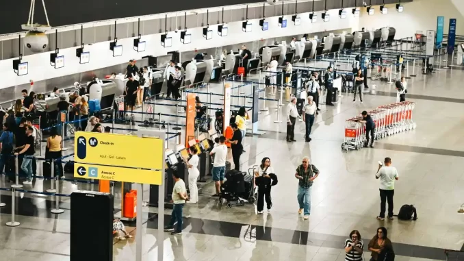 asur-compra-concessoes-aeroportos-motiva-115-bi Movimentação de passageiros e filas no aeroporto durante o processo de check-in, evidenciando a operação de aeroportos sob concessão.