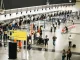 Movimentação de passageiros e filas no aeroporto durante o processo de check-in, evidenciando a operação de aeroportos sob concessão.