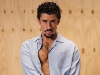 Bad Bunny disputa as três principais categorias do Grammy 2026, destaque da música latina, em foto de estúdio com fundo de madeira e expressão confiante.