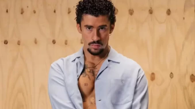 bad-bunny-disputa-tres-principais-categoria-grammy-2026-jpg Bad Bunny disputa as três principais categorias do Grammy 2026, destaque da música latina, em foto de estúdio com fundo de madeira e expressão confiante.