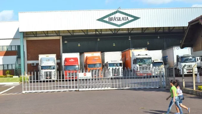 brasilata-vagas-em-cinco-estados-jpg Imagem da fábrica da Brasilata com diferentes caminhões estacionados na frente, indicando oportunidades de emprego em cinco estados.