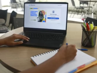 Pessoa verificando a lista de aprovados no Concurso Nacional Unificado no notebook, participando do processo de convocação de 3,9 mil aprovados.