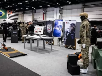 Comissão de segurança do COP Internacional 2025 exibindo equipamentos militares e tecnologias de defesa com presença de militares e displays no evento em São Paulo.
