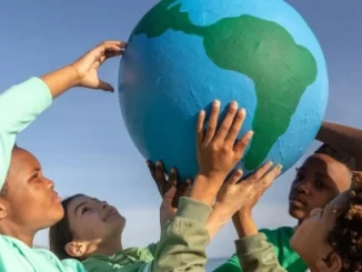 Crianças na COP30 cobram espaço e se dizem vítimas do clima, segurando um globo terrestre símbolo do movimento ambientalista.